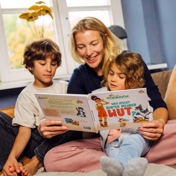 Frau und zwei Kinder lesen das Buch