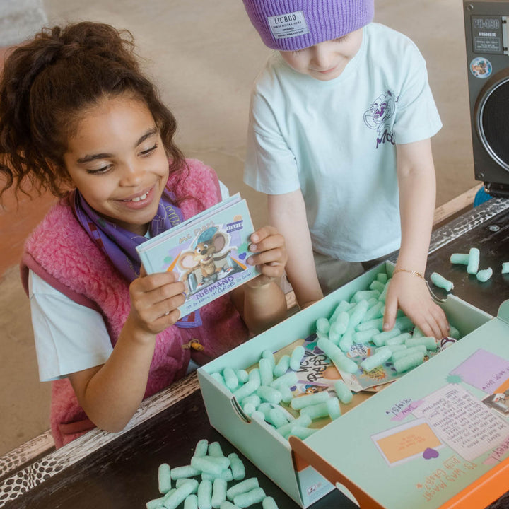 Zwei Kinder packen die Box aus
